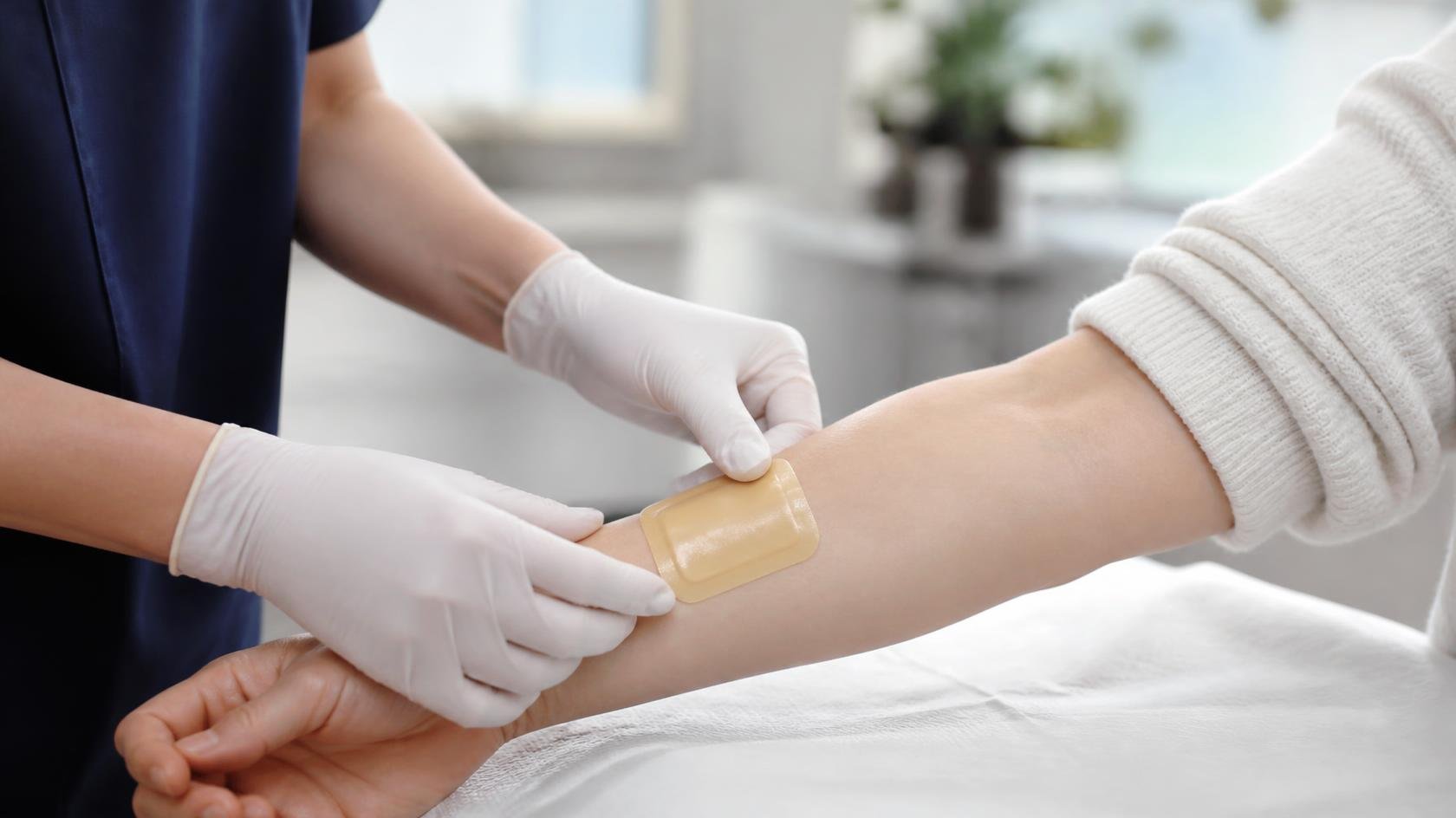 Clinician applying a foam dressing in a wound clinic (illustrative)