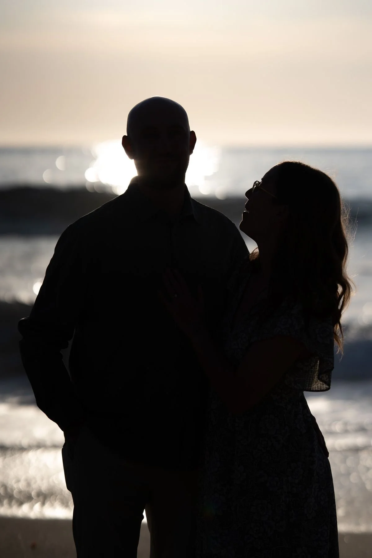 Couple laughing together during a golden hour engagement session