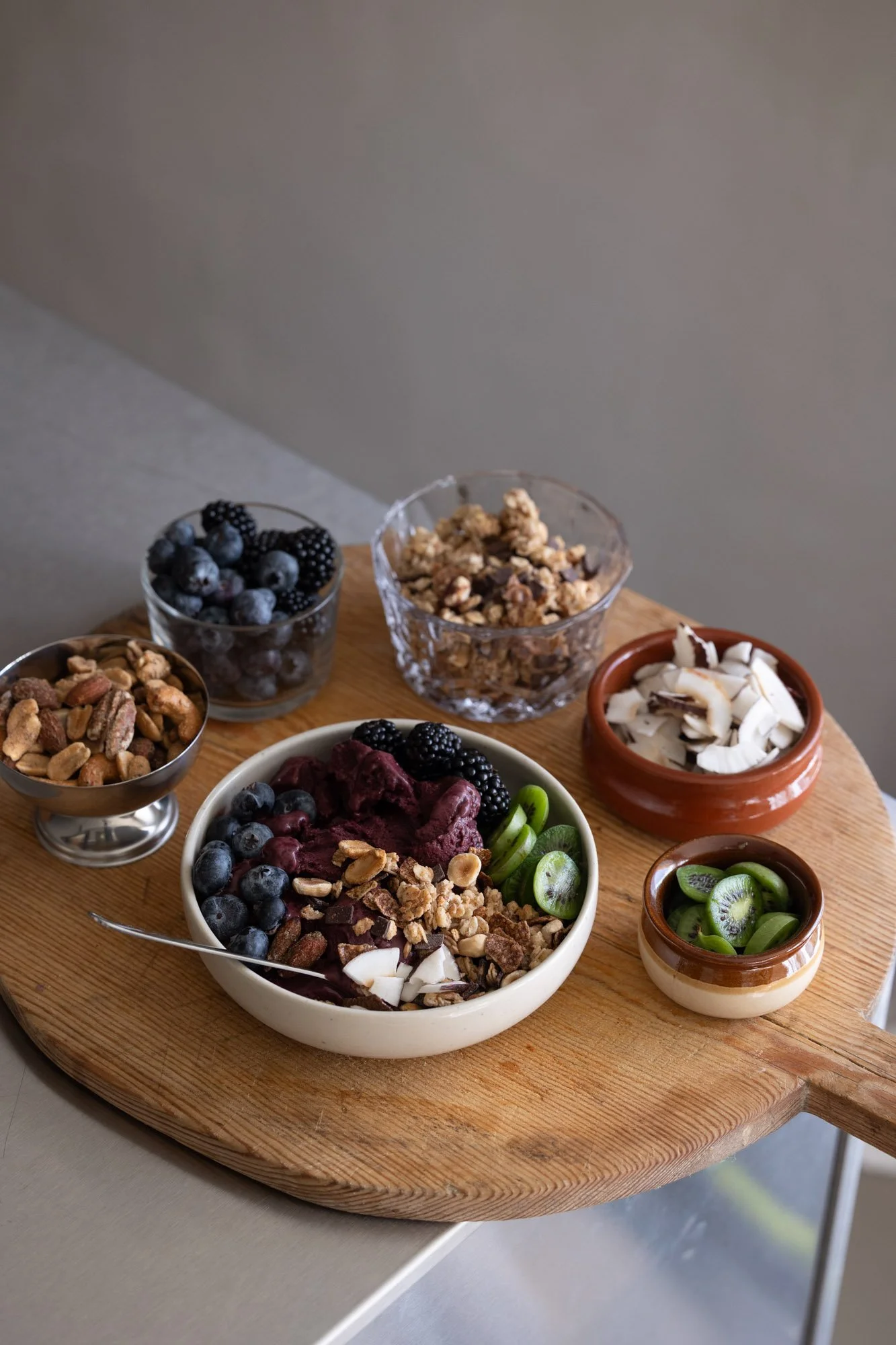 Açaí bowl med toppingbar av nøtter, bær og kokos
