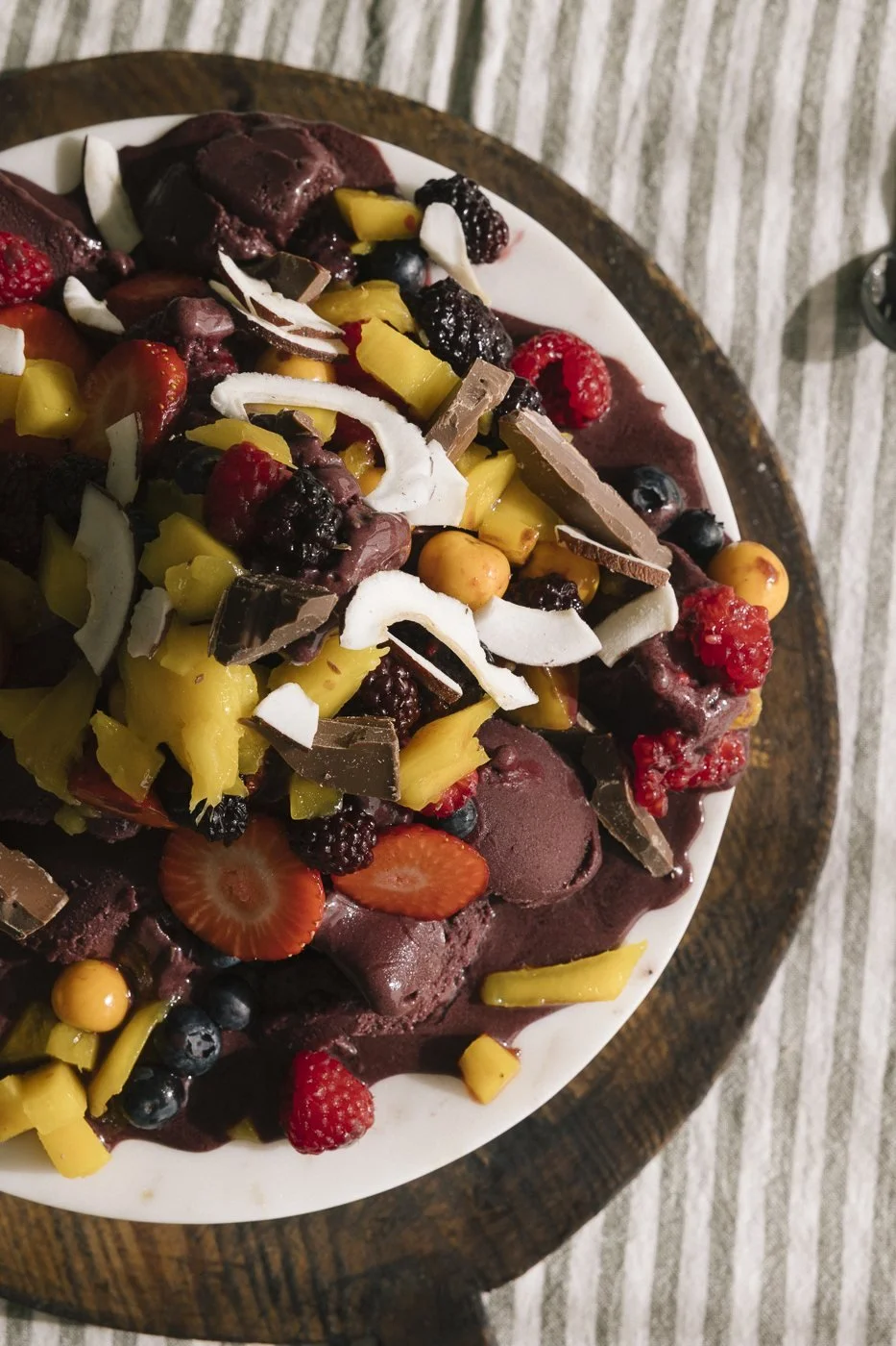 Nærbilde av açaídessert med mango, jordbær, sjokolade og kokos
