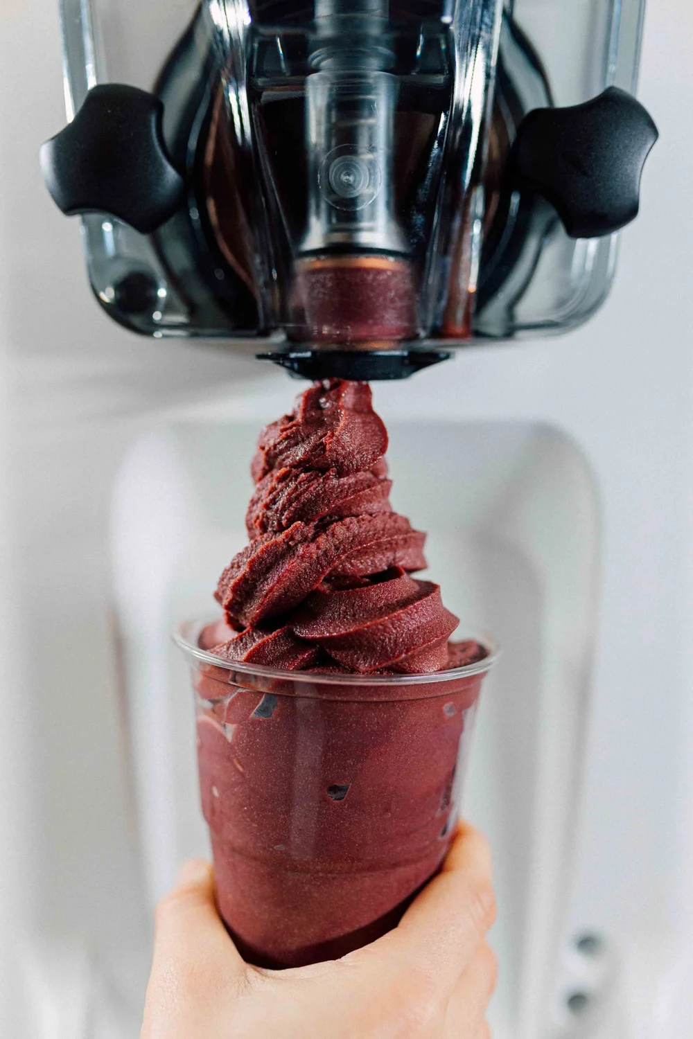 Açaí soft serve tappes rett i høyt plastbeger