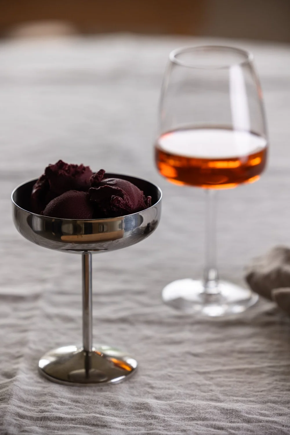 Sorbetto all'açaí servito in una coppa con un bicchiere di vino