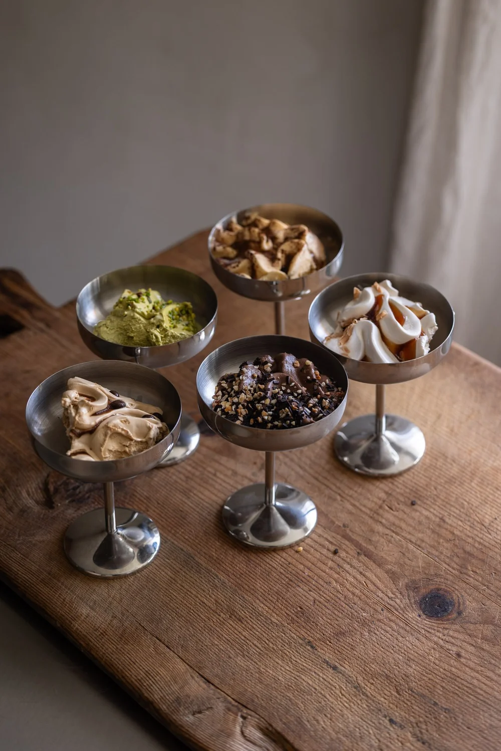 Gelato italiano servito in coppa su un tavolo di legno.