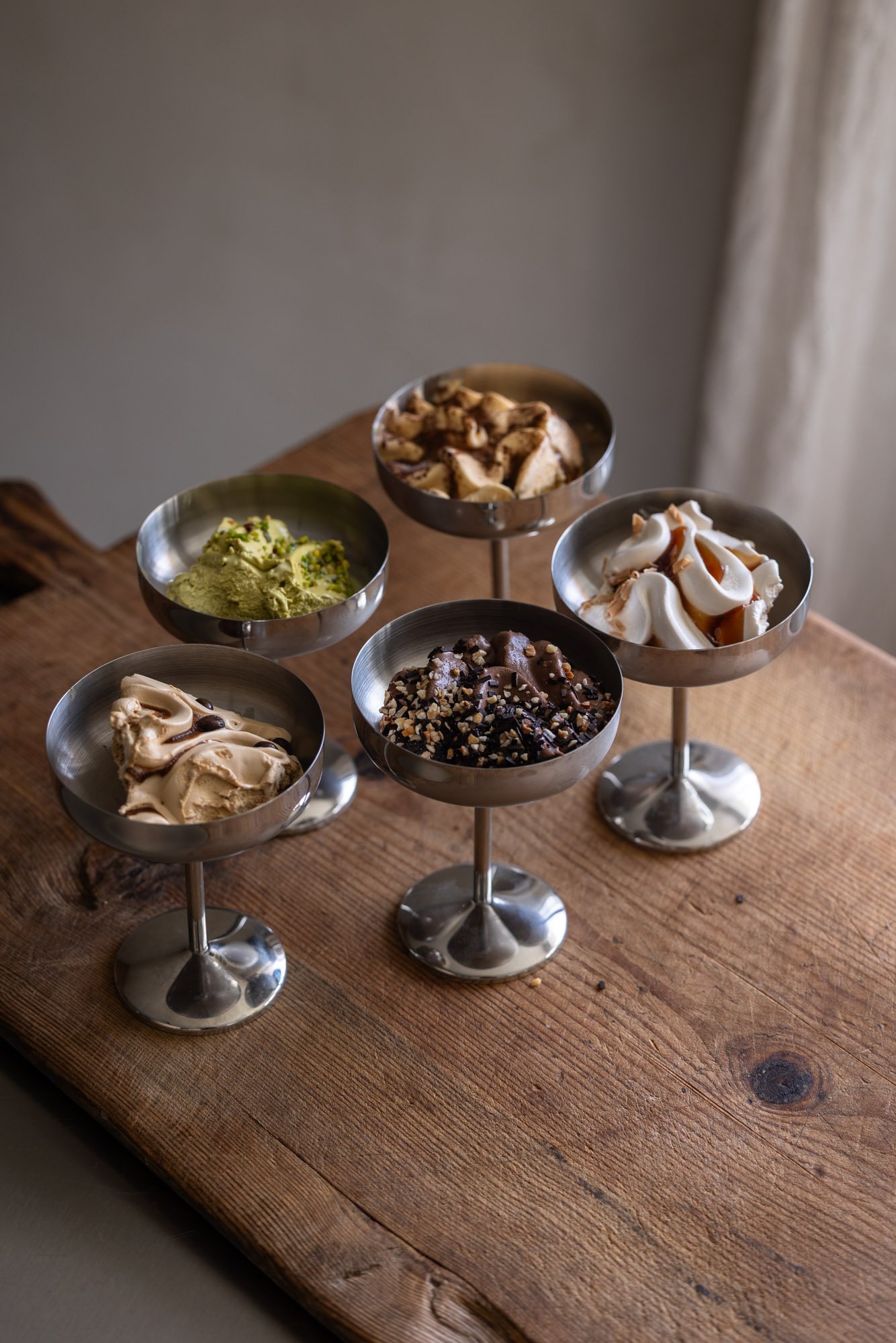 Italiensk gelato i coupe-glass på trebord