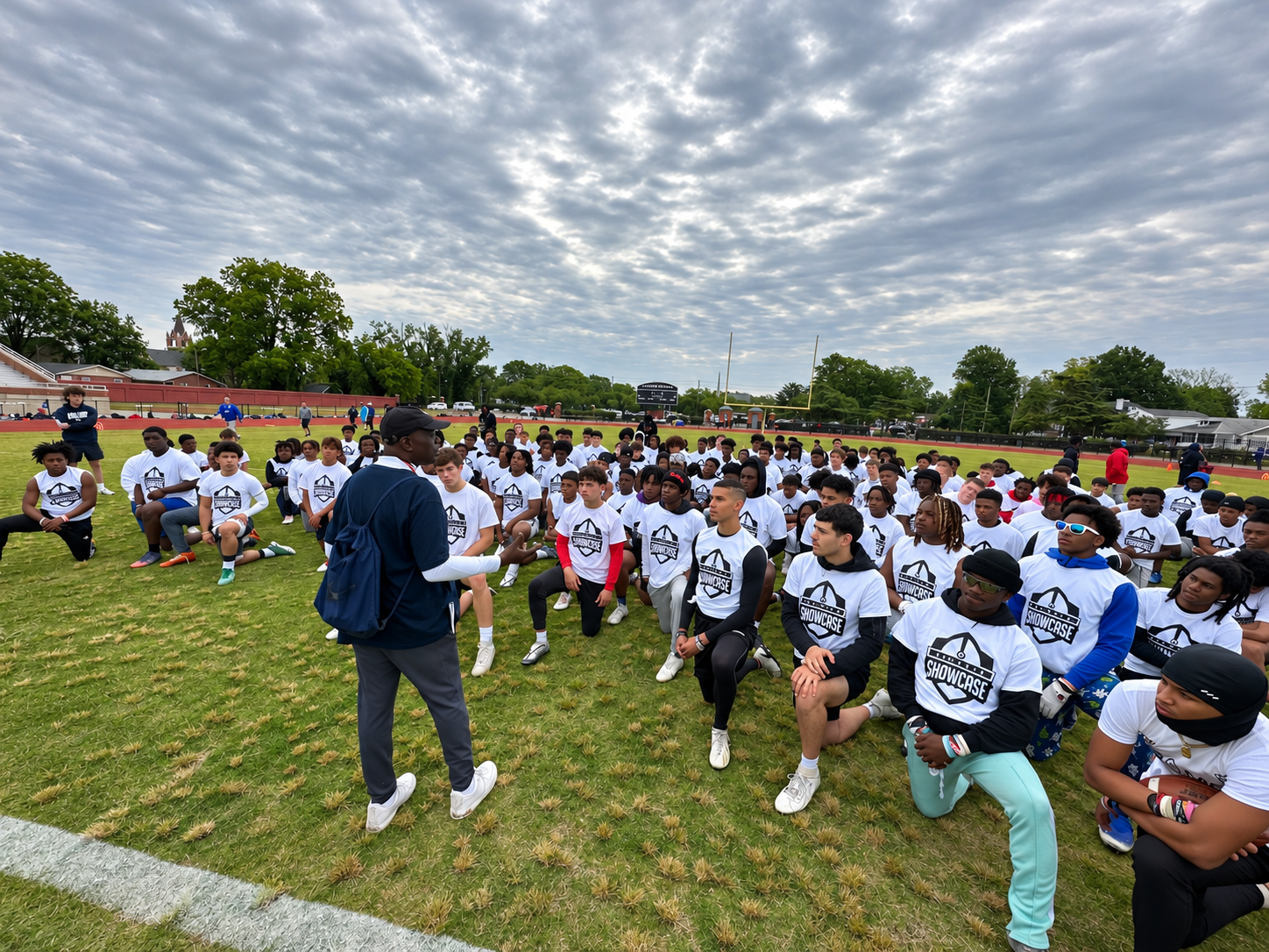 Tommy Reamon Sr. speaking to kneeling high school athletes at the 2023 Peninsula Showcase in Hampton, Virginia.