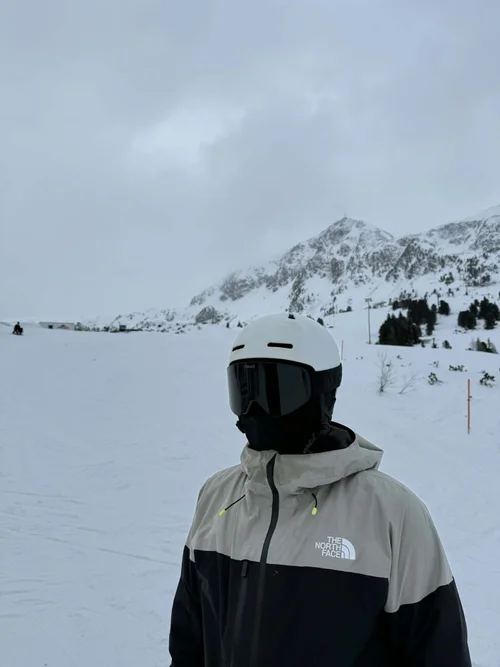 Skiløber med TORAN skibrille foran bjergkam i overskyet vejr