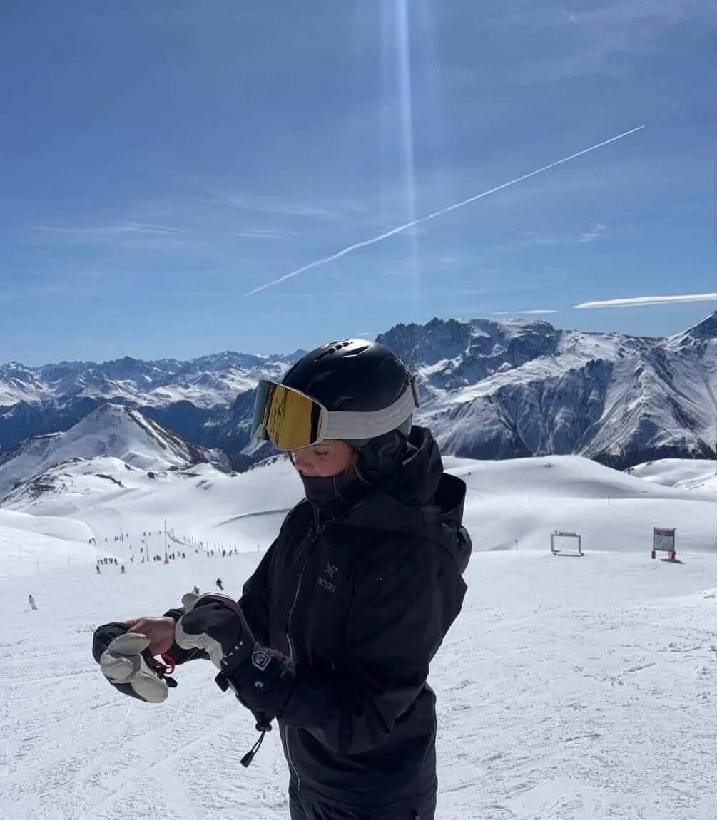 Snowboarder med TORAN skibrille står i solskin foran alperne