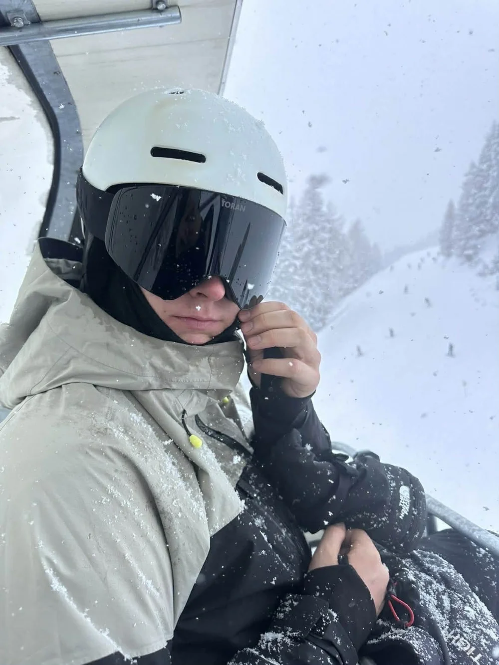 Skiløber i stoleliften med TORAN skibrille og hætte i whiteout