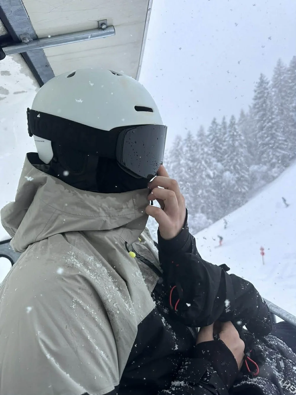 Skiløber i stoleliften med TORAN skibrille på vej op gennem skyerne