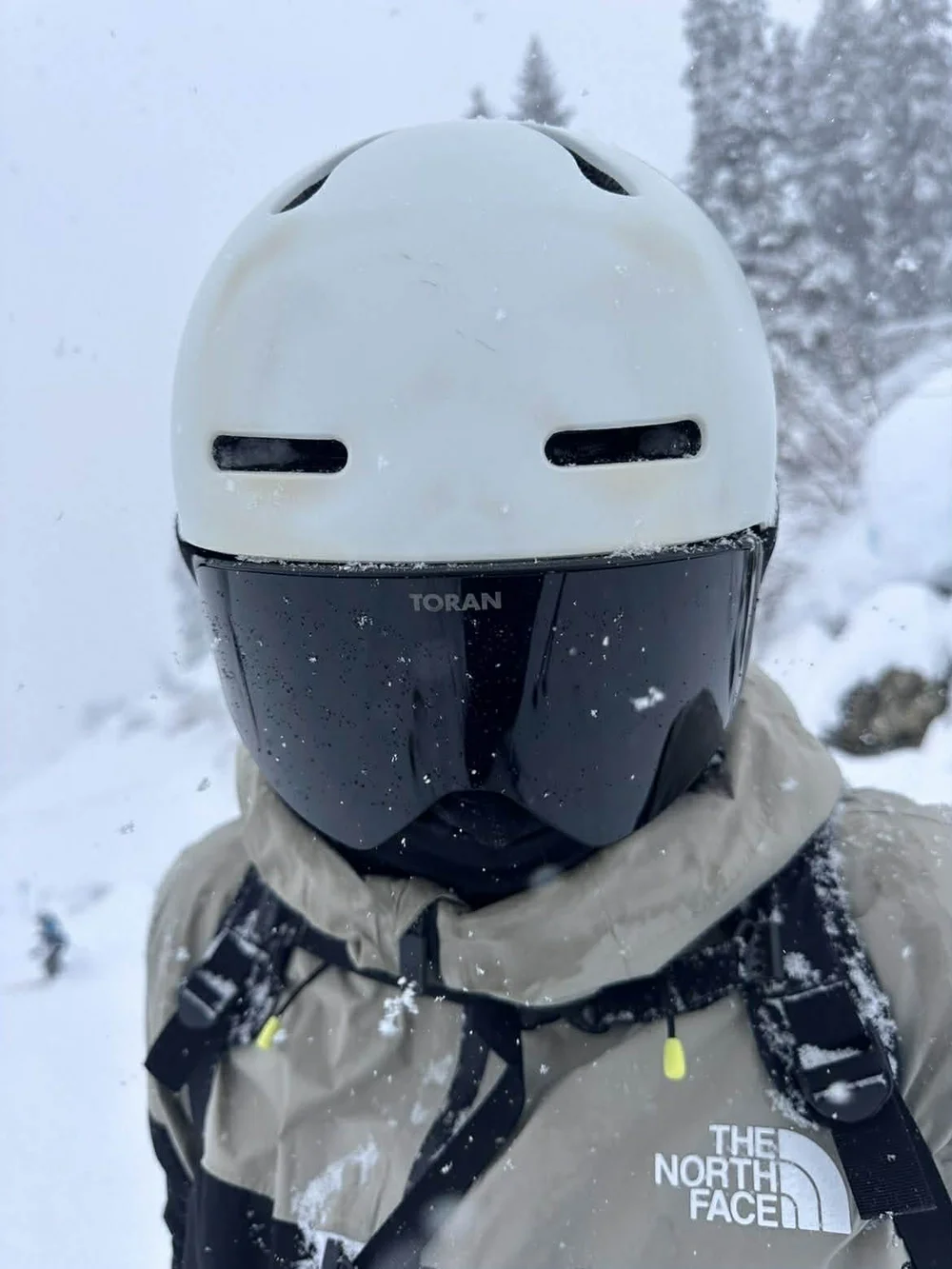 Nærbillede af hvid skihjelm og sort TORAN skibrille med magnetisk linse