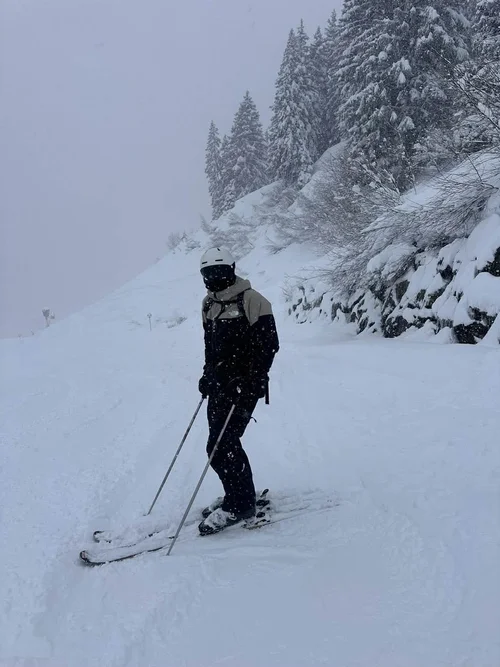 Skiløber med TORAN skibrille på pisten mellem snedækkede graner