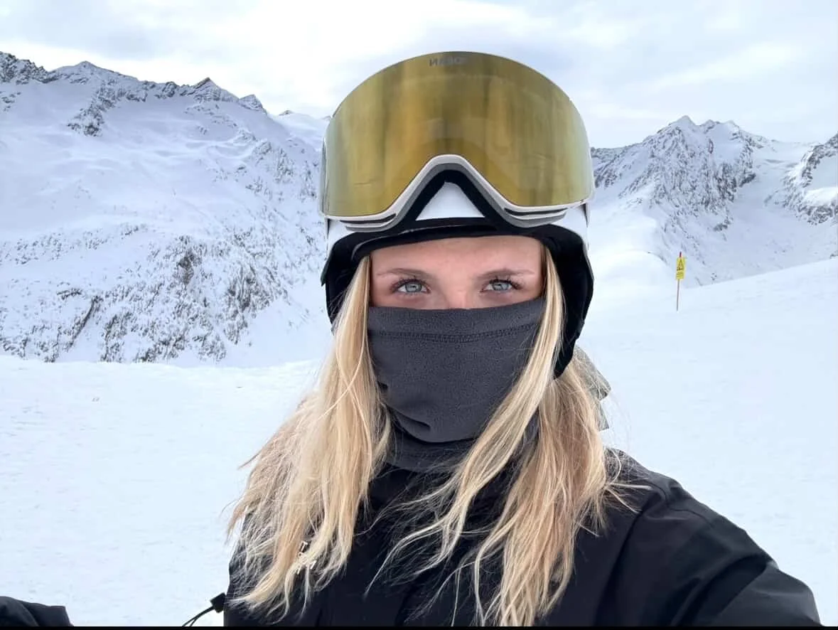Portræt af kvinde med guld TORAN skibrille og halsedisse i solskin på bjerget