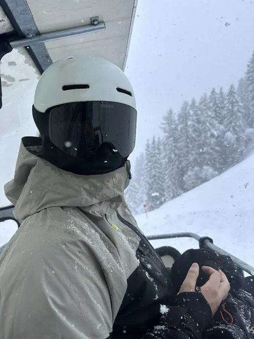Skiløber med hvid hjelm og TORAN skibrille i stoleliften