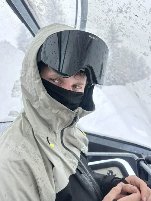 Skiløber med hætte og sort TORAN skibrille i stoleliften