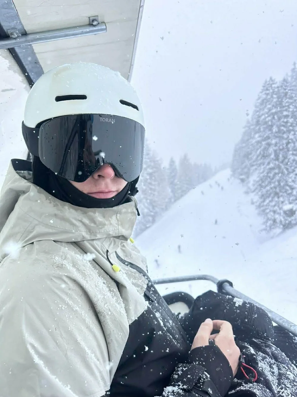 Selfie i stoleliften med hvid hjelm og TORAN skibrille i whiteout
