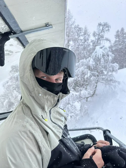 Skiløber med TORAN skibrille i stoleliften med sne på træerne