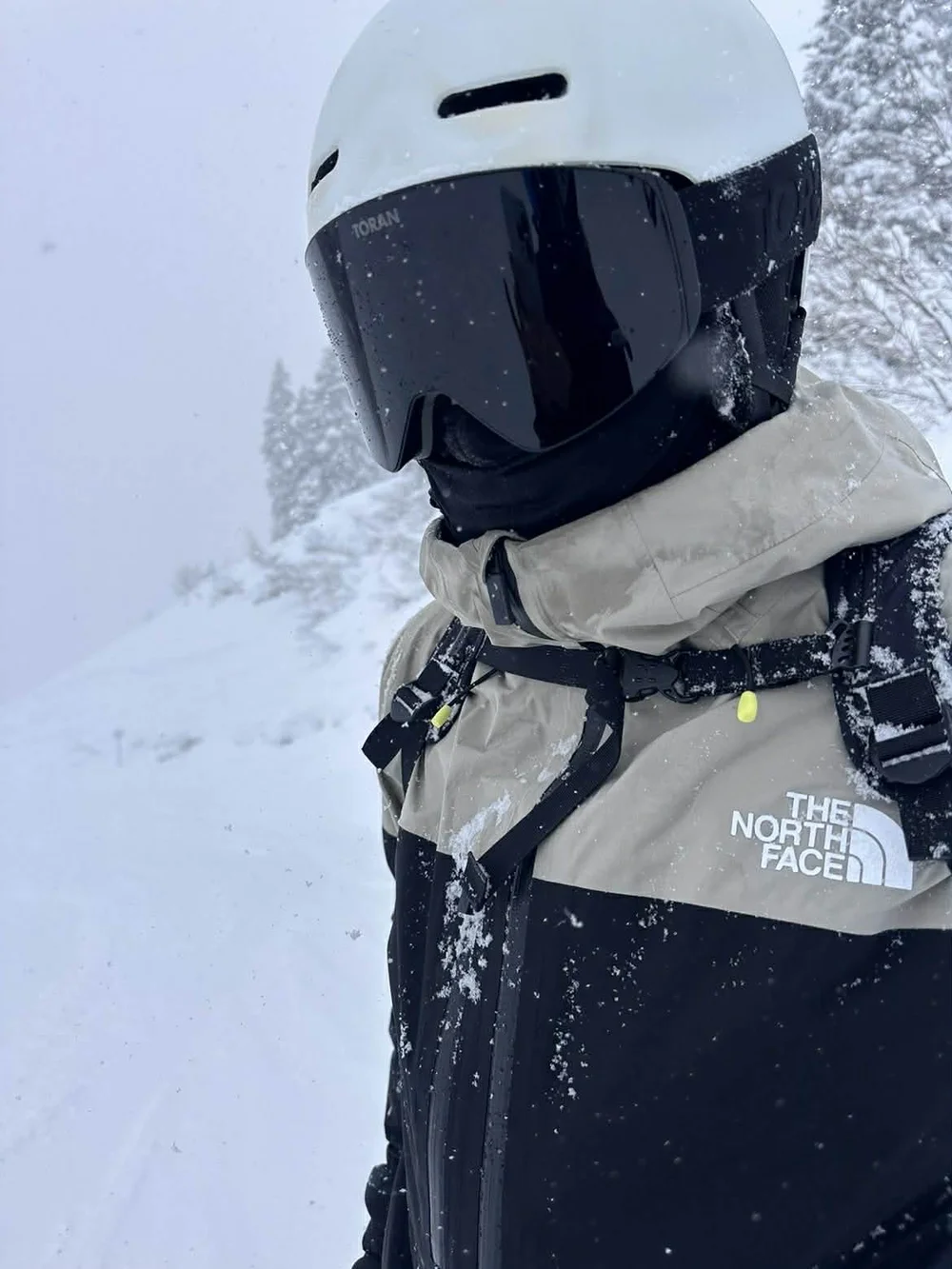 Skiløber med hvid hjelm og TORAN skibrille i kraftigt snefald
