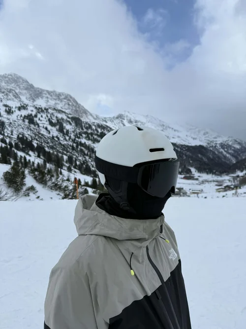 Skiløber med TORAN skibrille foran bjergkæde i overskyet vejr