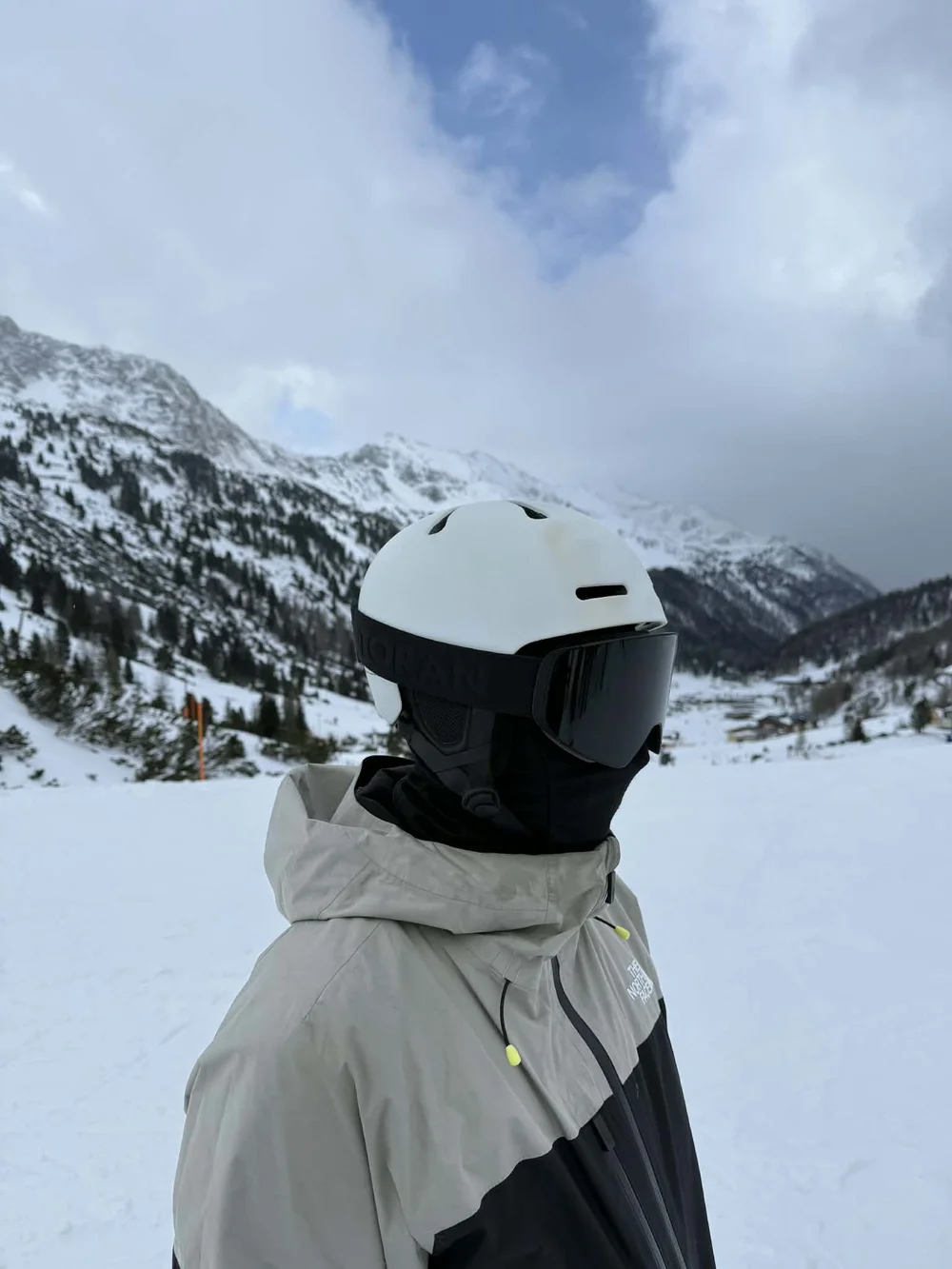Skiløber med TORAN skibrille foran bjerge og blå himmel mellem skyerne