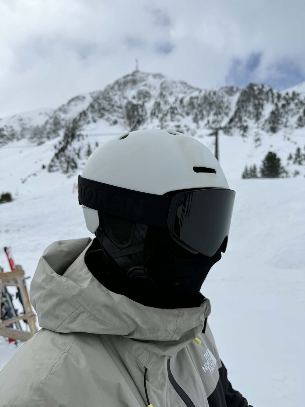 Skiløber med TORAN skibrille og ansigtsmaske foran bjergtop
