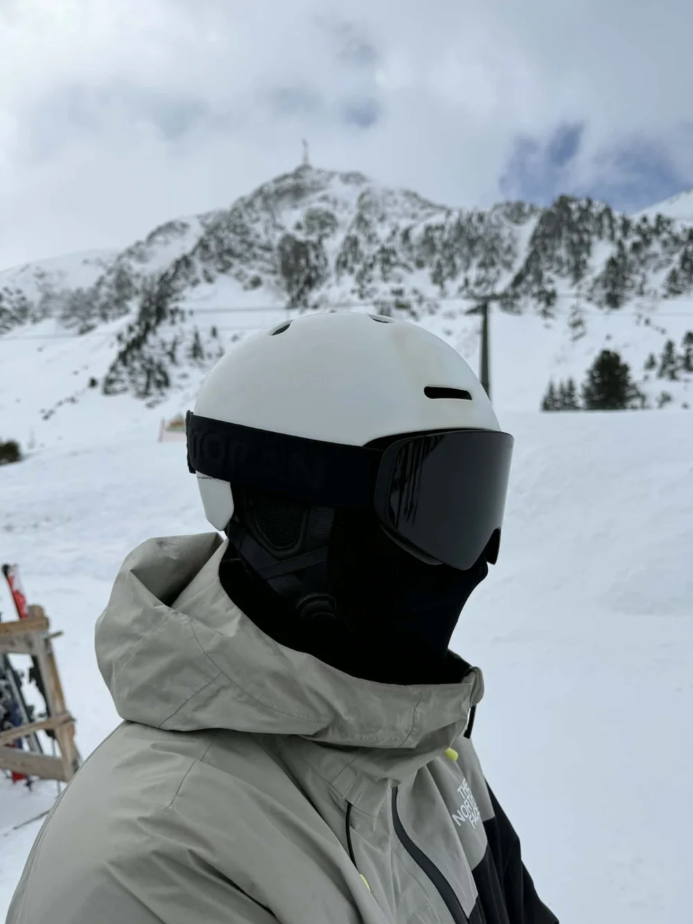 Skiløber med TORAN skibrille og sort halsedisse foran snedækket bjergkam