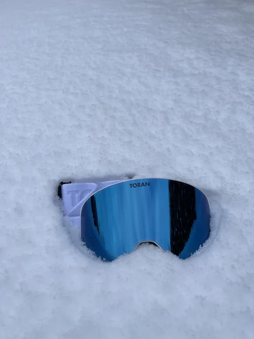 TORAN Glacier skibrille med blå spejllinse set fra siden i sneen
