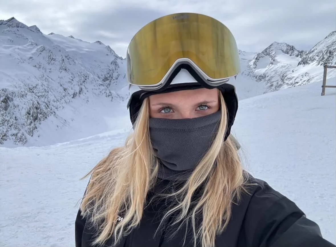 Kvinde med lyst hår og guld spejlglas TORAN skibrille ved bjergkam