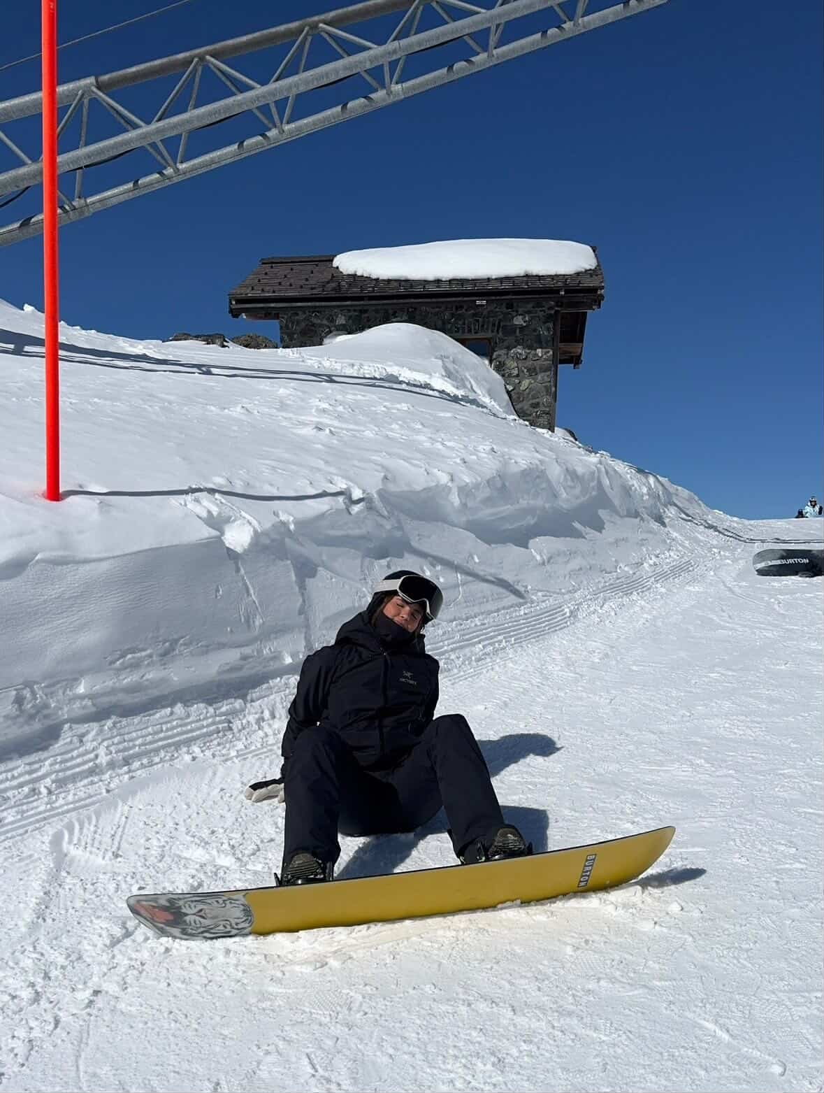 Snowboarder med TORAN skibrille sidder på sit gule board ved liften