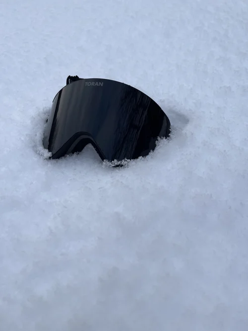 TORAN Midnight skibrille med mørk linse liggende i pudder