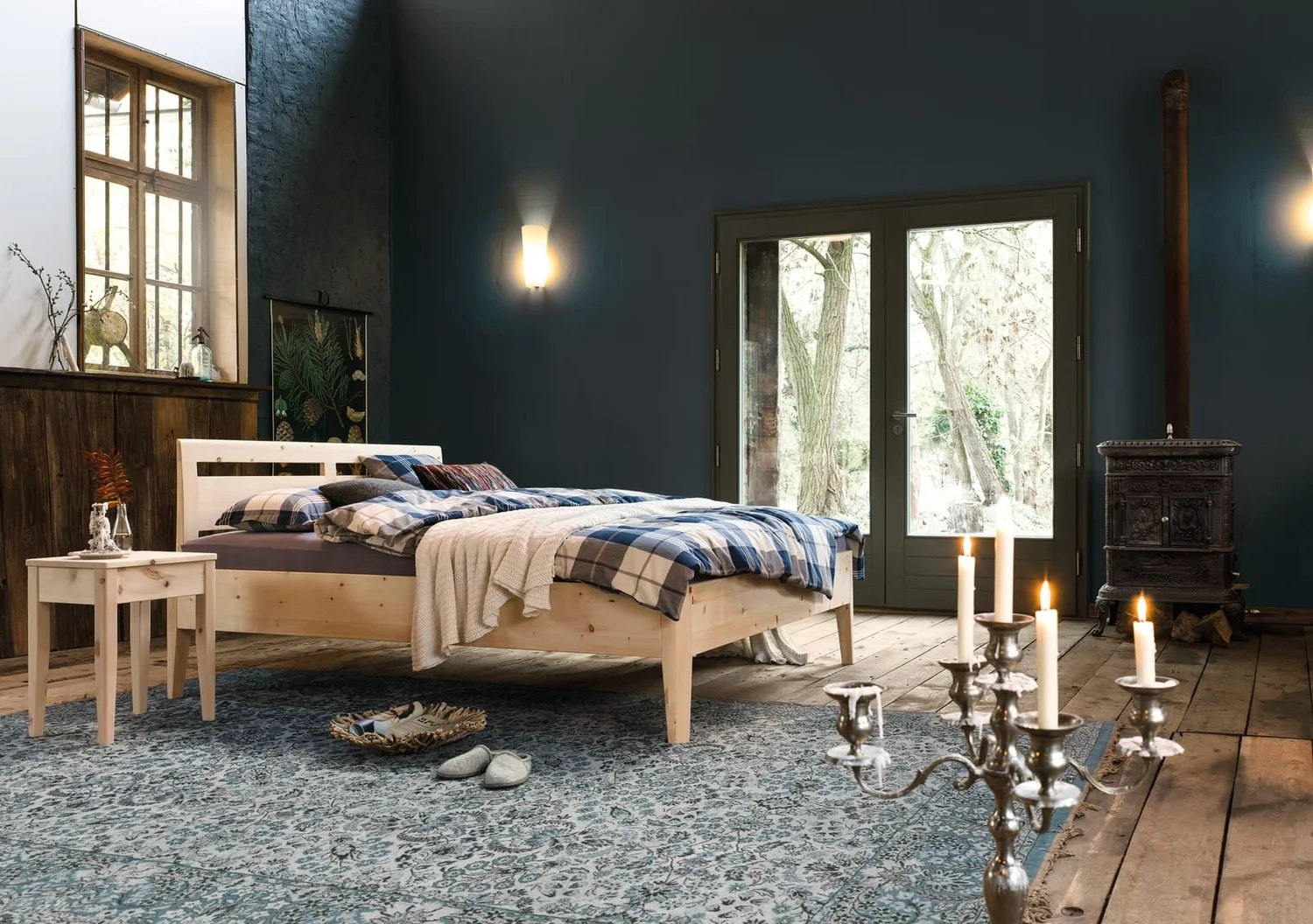 Dormiente Kalmera bed in untreated Swiss pine in a candlelit bedroom
