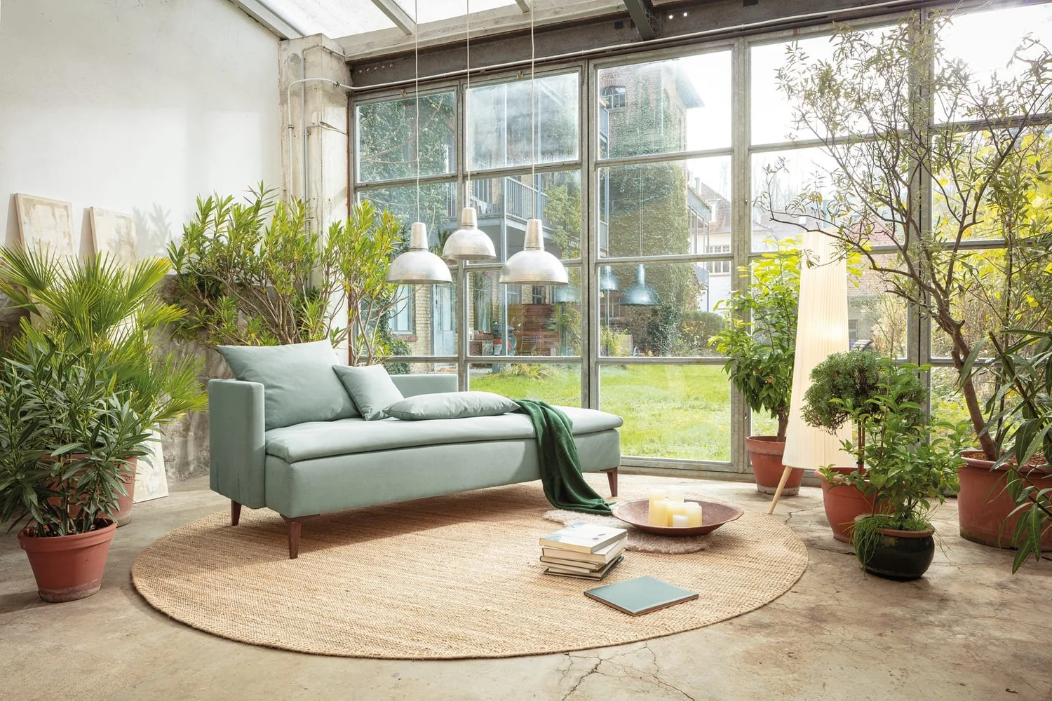 Dormiente Daybed chaise sofa bed in sage green in a bright garden room