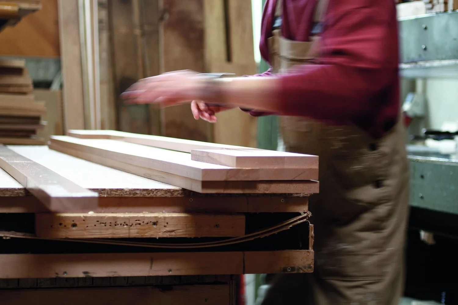 Woodworker planing solid timber boards