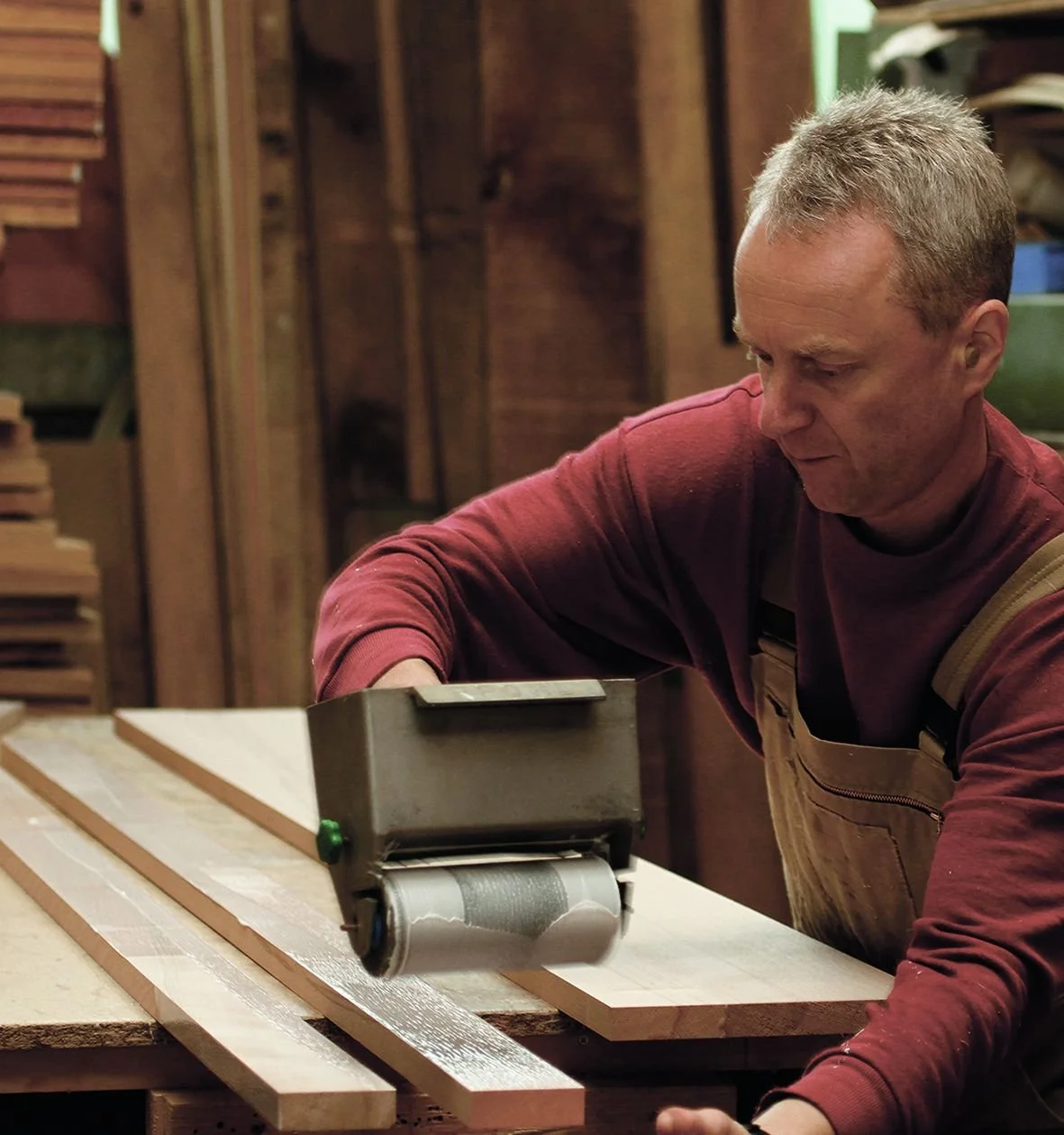 Craftsman shaping a solid wood bed part in the Dormiente workshop