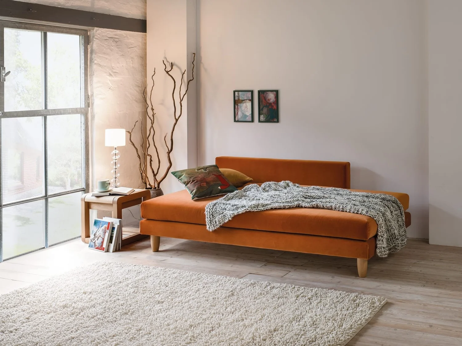 Dormiente Lounge S made up as a bed with a throw