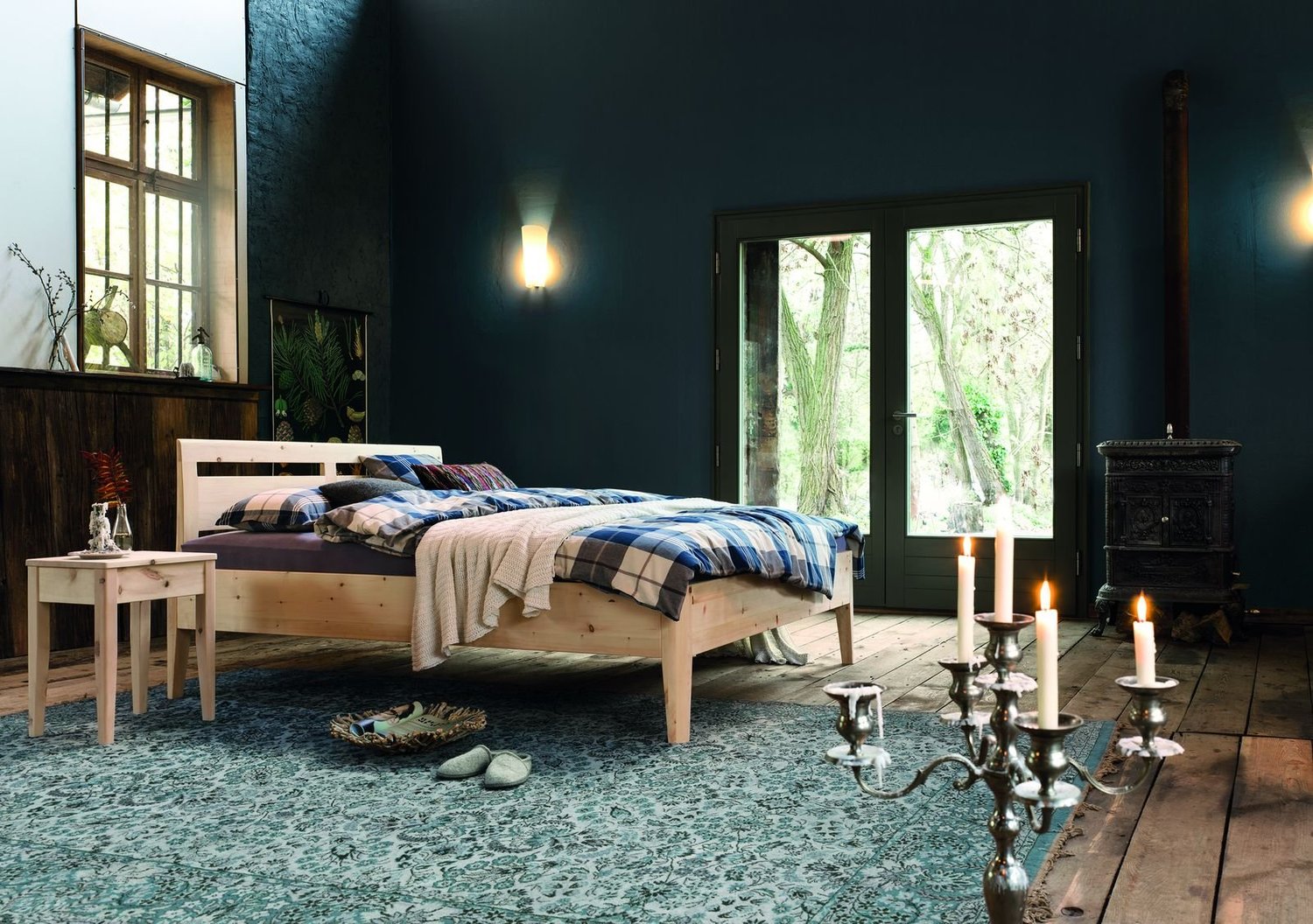 Dormiente Kalmera solid Swiss pine bed in a candlelit bedroom