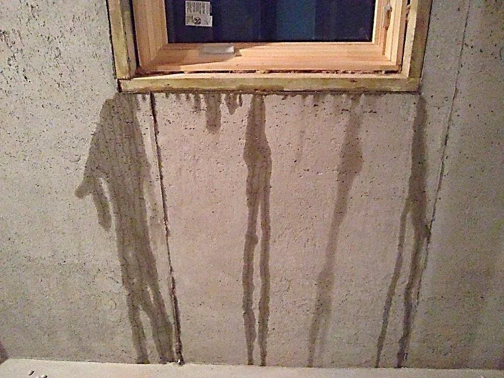 Vertical crack with water staining — a shrinkage crack that leaks. Common; watch for offset.