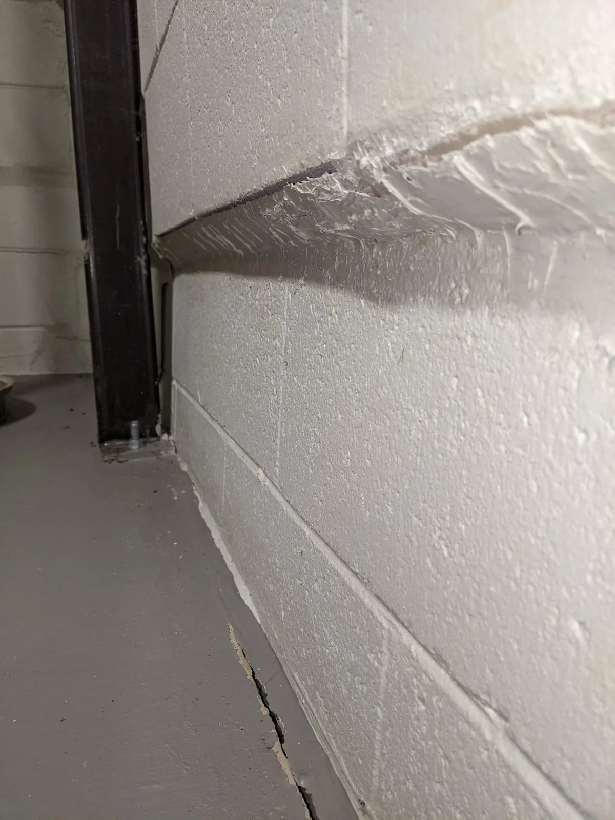 Looks like the wall slid inward. Sight along it: the bottom two courses rotated OUT with the footing, and the upper courses are plumb.