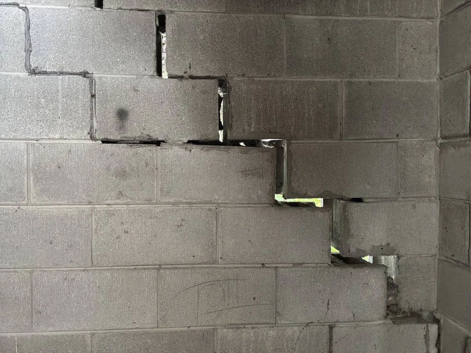 Large step crack, widest at the top and tapering to the floor.
