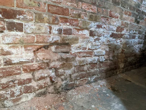 Brick foundation wall with mortar loss and staining