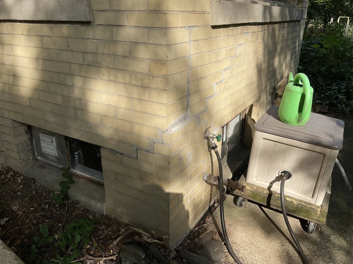 Step crack in the block veneer widening toward the top, at the corner that dropped.