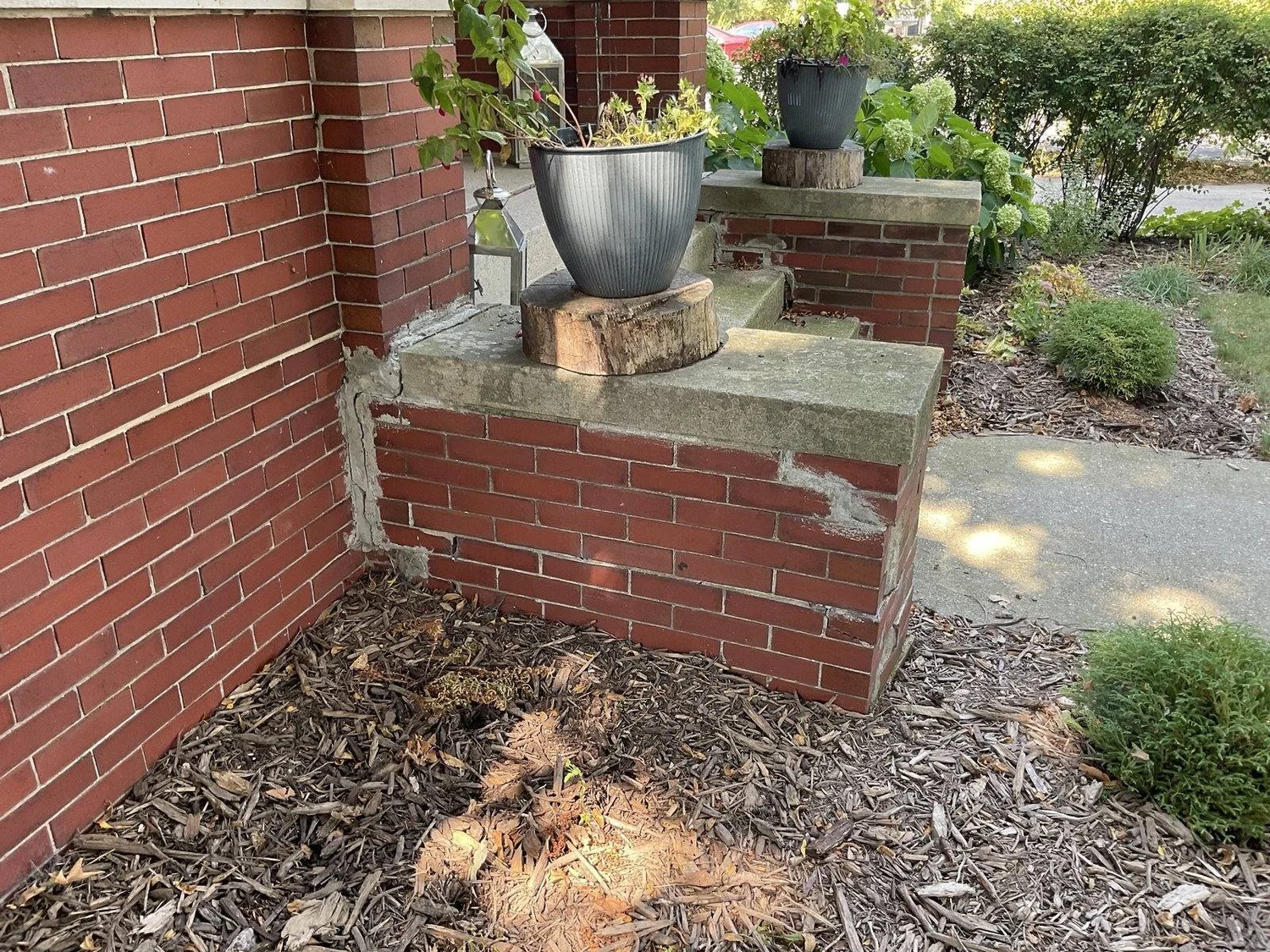 The brick stoop and veneer pulling away from the house on the same corner.