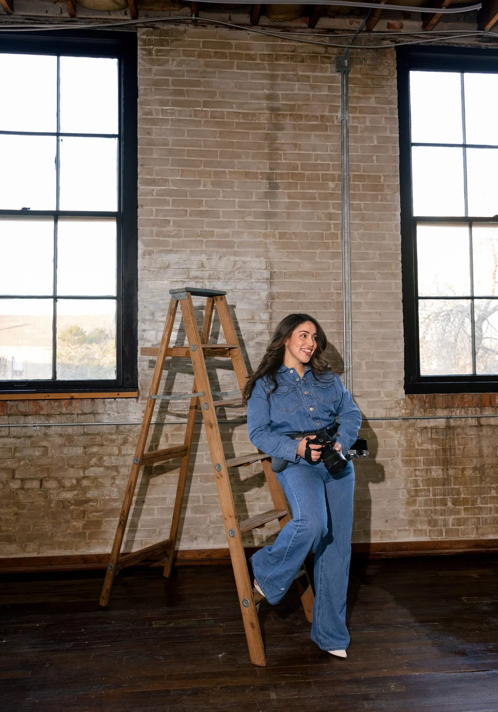 Aby, owner of Buena Vista Studio, holding her camera inside the San Antonio photography studio