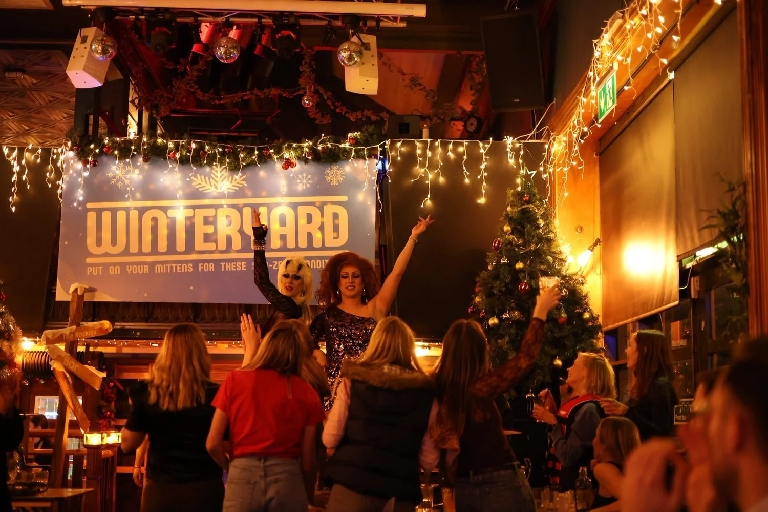 Drag queens performing on stage to a cheering crowd at The Bernard Shaw