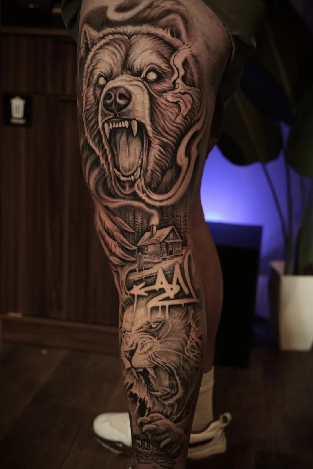 Black and grey wildlife leg sleeve with a roaring bear, cabin, forest and tiger by Luis Dajer in Charlotte, NC.