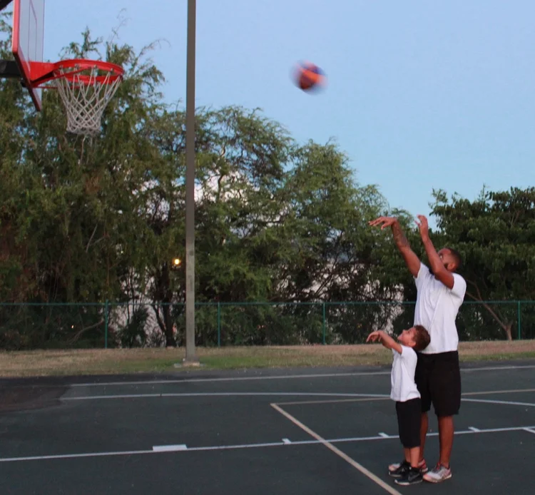 A father and son playing basketball