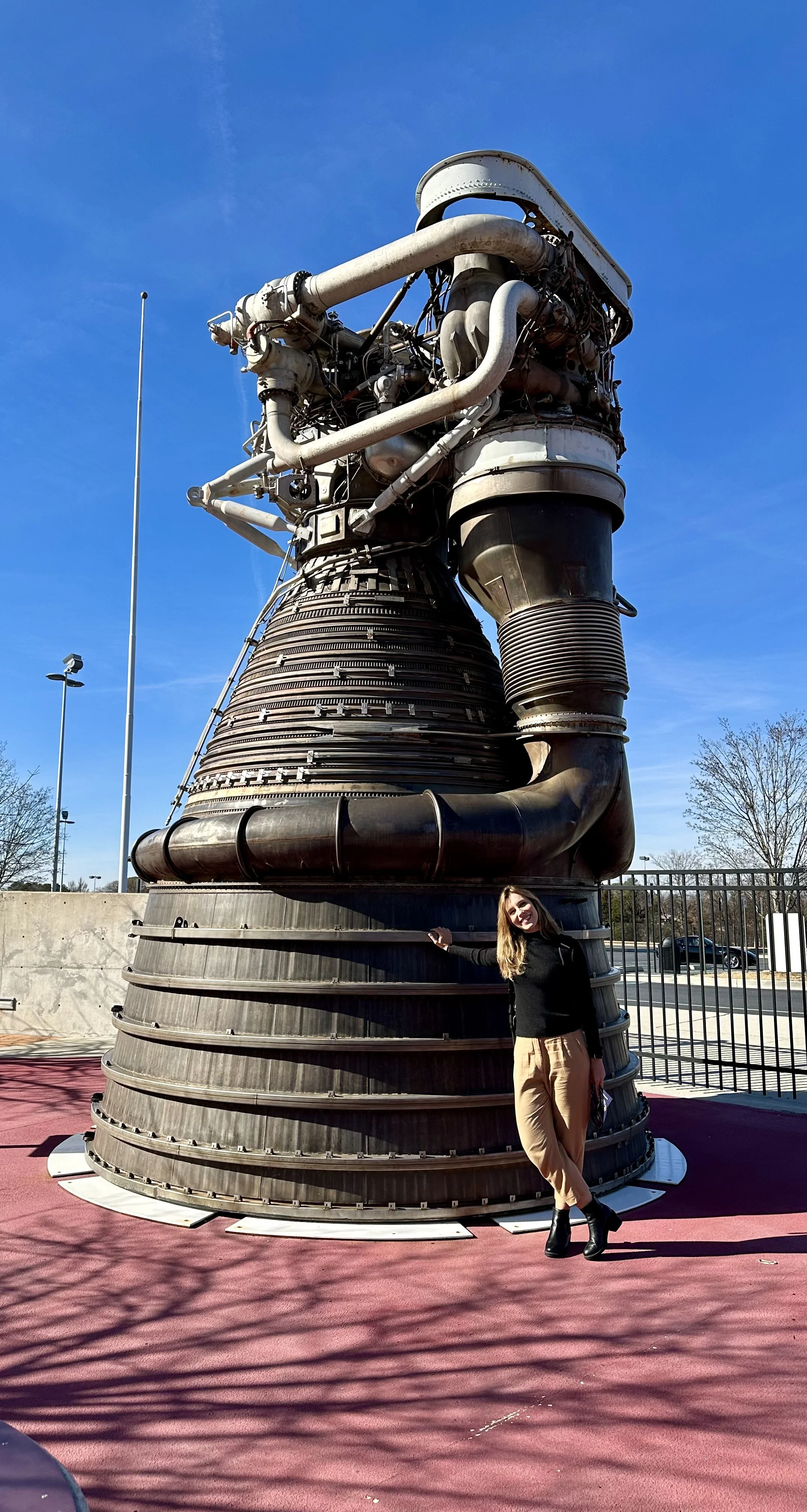 Mariana Barbosa beside a large rocket engine