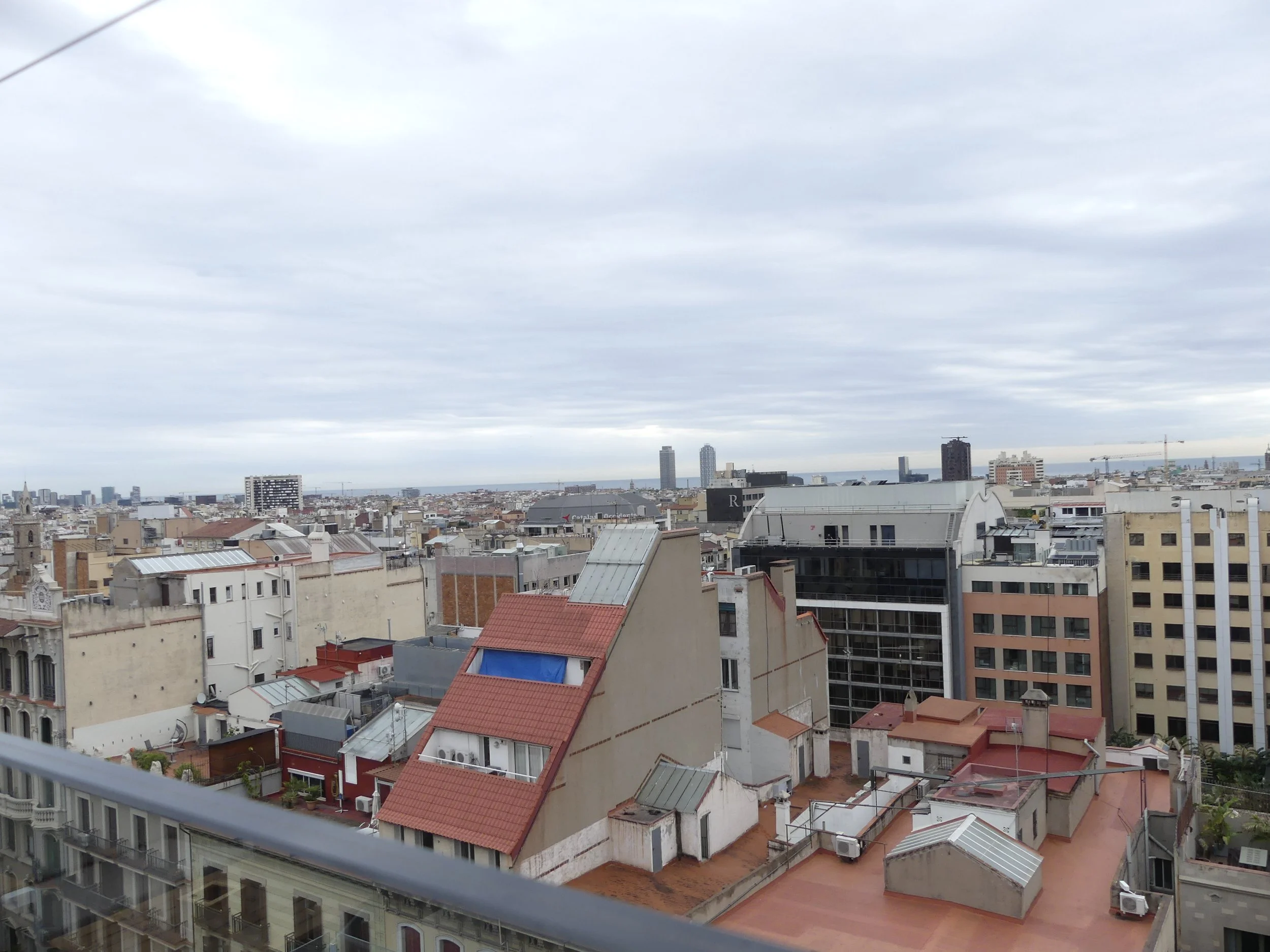 Rooftop panorama over Barcelona's red-tiled roofs.