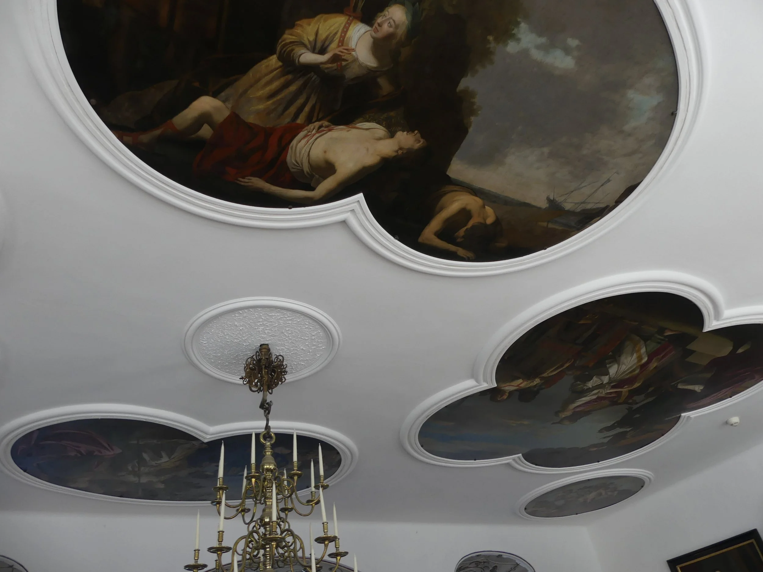 Painted ceiling frescoes and a chandelier inside Kronborg.