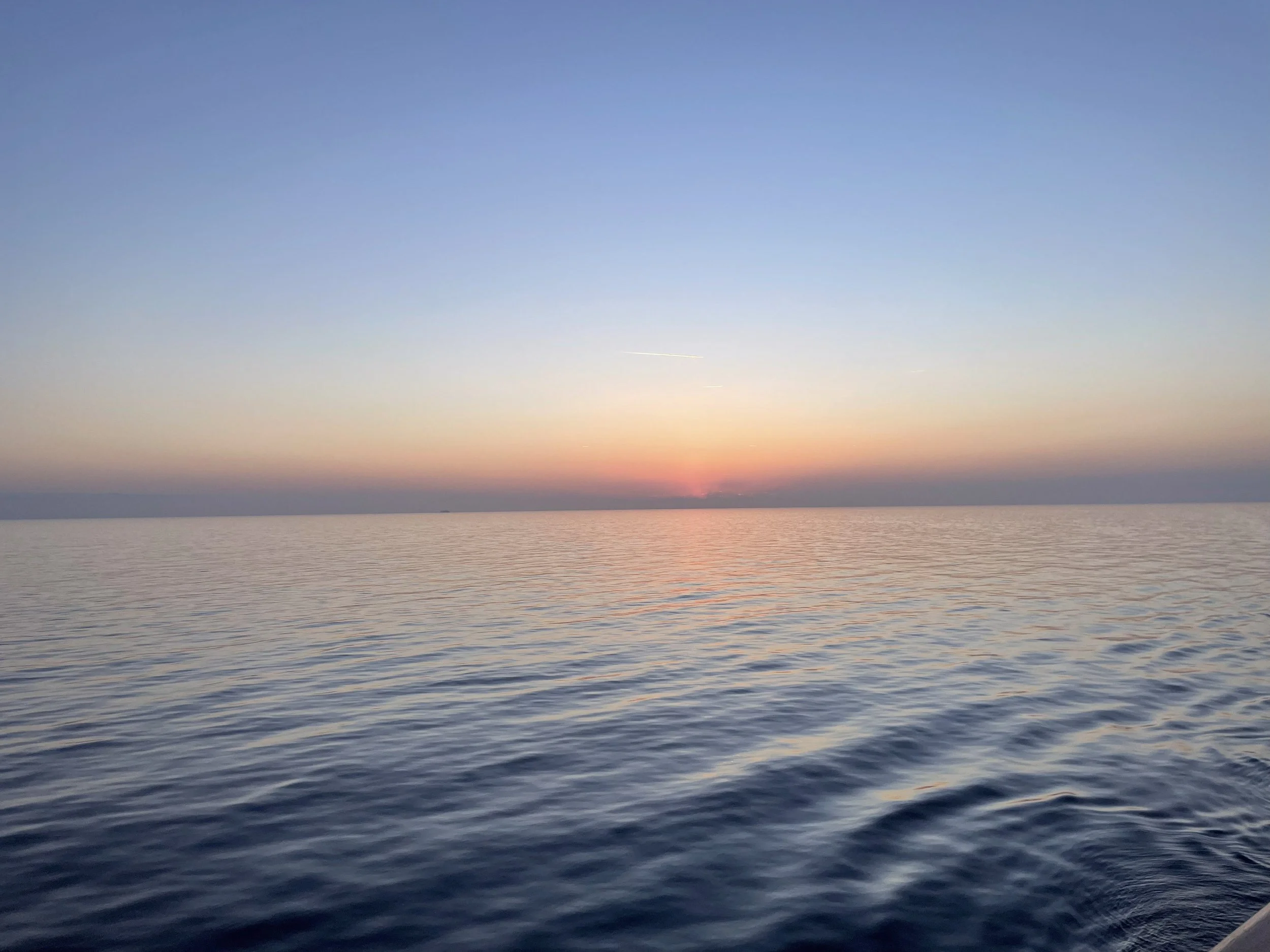 Sunset over a calm sea from the ship.