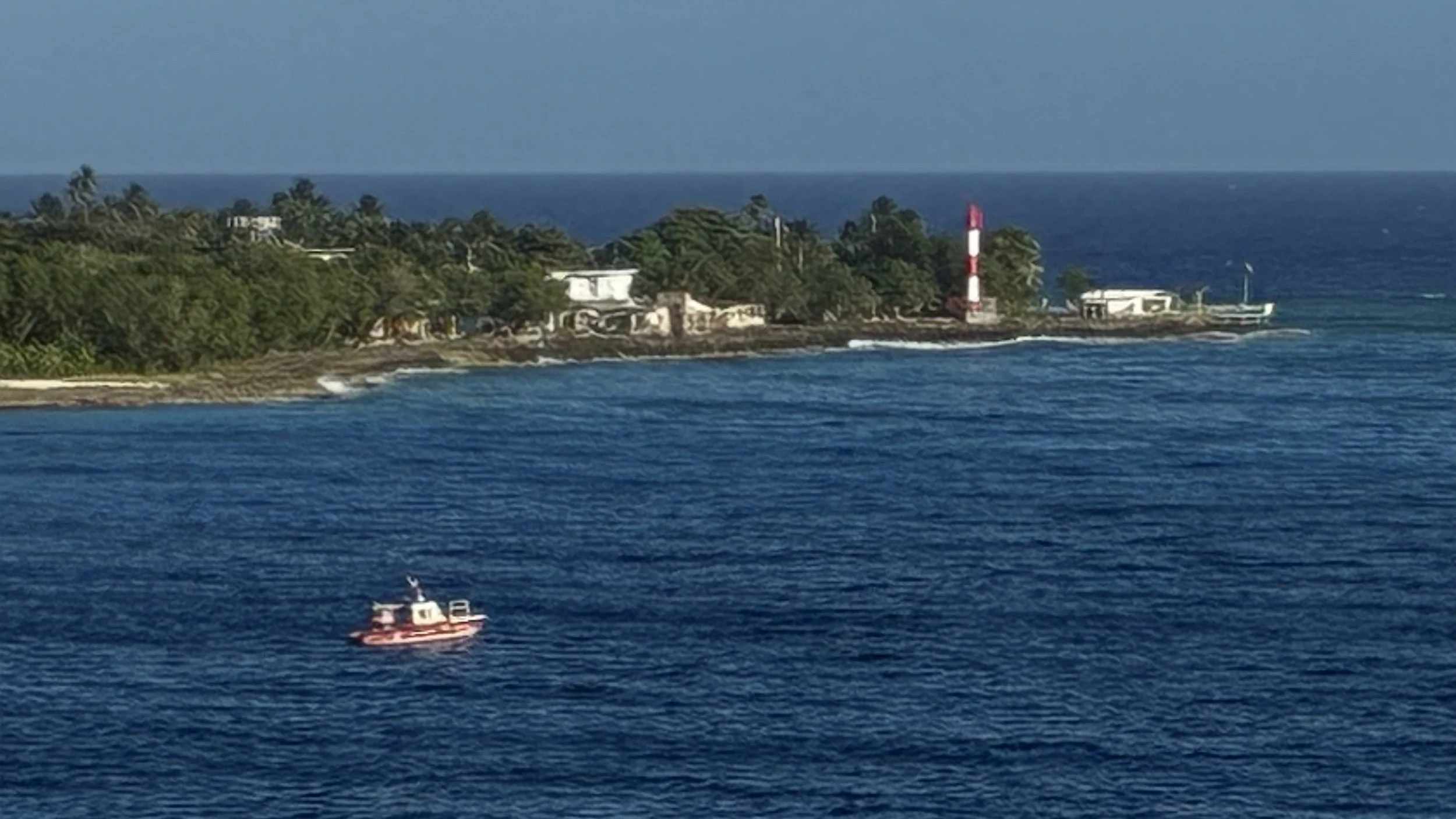 Sail-away — a lighthouse point and a passing sailboat.